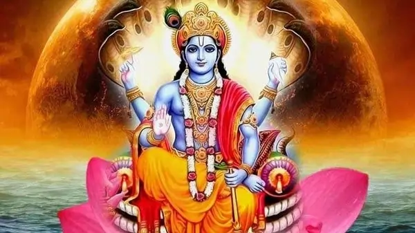 Blue-skinned Vishnu sits on a pink lotus, four-armed, holding conch, discus, mace, blessing hand.